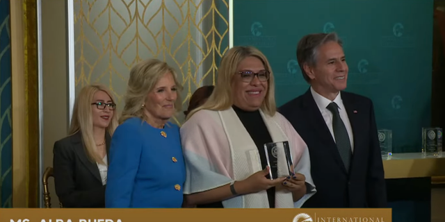 Jill Biden gives a Man an award on International Women's Day